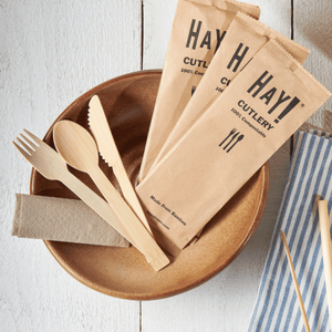 HAY Bamboo Cutlery About Page, Image shows wrapped and unwrapped bamboo cutlery in a natural serving bowl with striped napkin