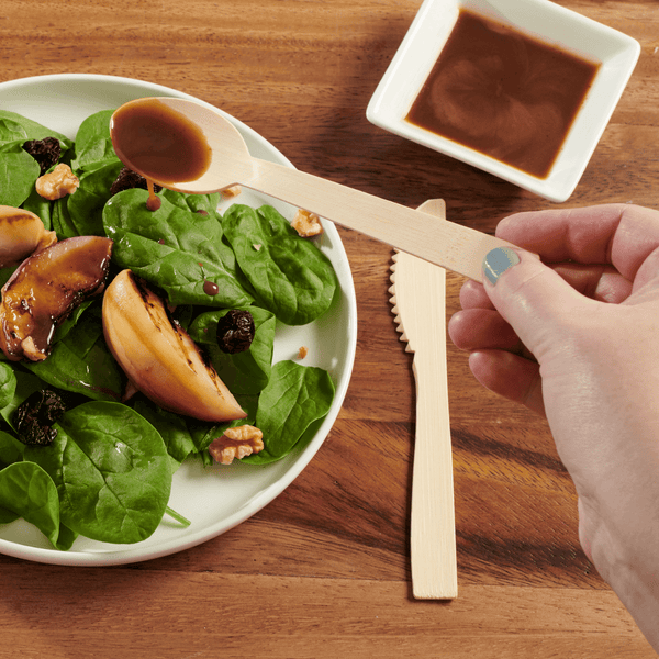 Hay Straws Bamboo Cutlery, unwrapped bamboo cutlery spoon drizzling dressing on salad