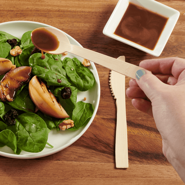 Hay Straws Bamboo Cutlery, unwrapped bamboo cutlery spoon drizzling dressing on salad