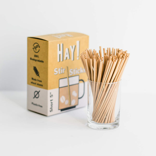 HAY! Stir Sticks displayed in short glass: 5in Short - Stir Sticks, made from the stem of a wheat plant, tested gluten-free and never soggy. Long 7.75" size also available.